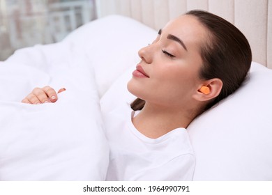 Young Woman With Foam Ear Plugs Sleeping In Bed