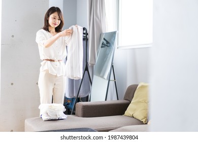 Eine junge Frau, die Wäsche zu Hause falten