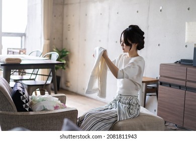 Young Woman Folding Laundry At Home