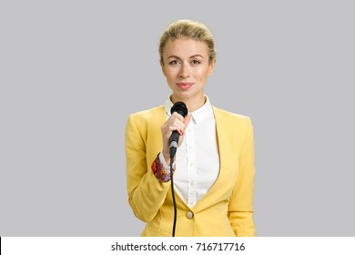 Young Woman In Formal Wear With Microphone. Young Business Woman Public Speaking Isolated On Grey Background.