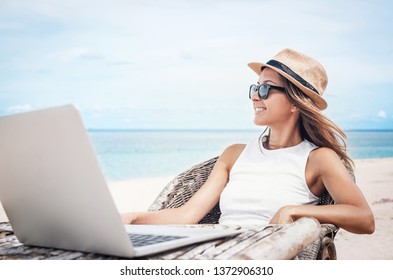 Young Woman Freelancer Working On The Beach 