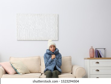 Young Woman Freezing Under Air Conditioner At Home