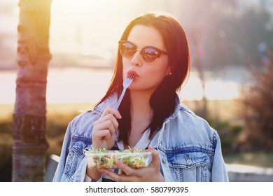 Young Woman With Fresh Salad And Outdoor, Fork In Mouth