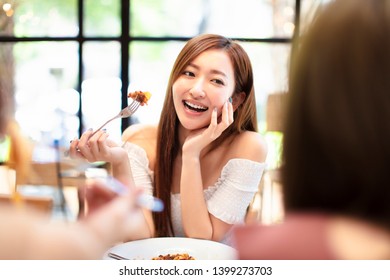 young woman with friends having dinner in the restaurant