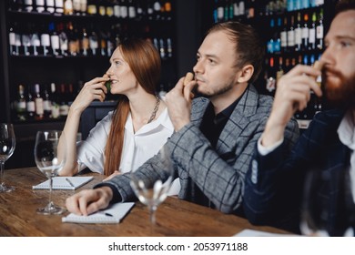 Young Woman With Friends Listens To Aroma Of Red Wine At Master Class Tasting In Restaurant, Training Sommelier.