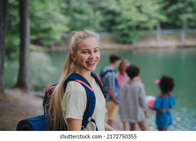 Young Woman With Friends On A Hiking Or Camping Trip In The Mountains In Summer.