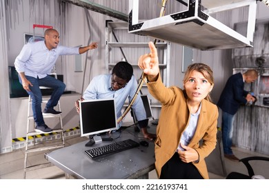 Young Woman With Friends Solving Puzzles In Quest Room, Reaching For Something