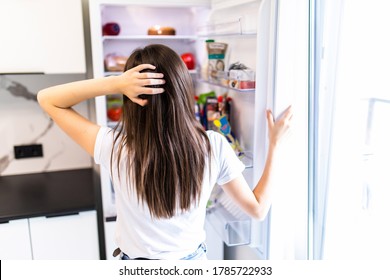 Young Woman In Front Of The Fridge