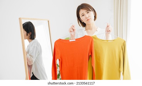 Young Woman In Front Of A Mirror Choosing Clothes Fashion Image