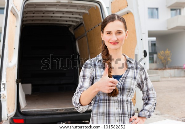 Young woman in front of moving truck, the van is\
still empty