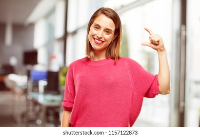 Young Woman Full Body. Smiling With A Satisfied Expression Showing A Small Object Or Concept, Holding It With Single Hand.