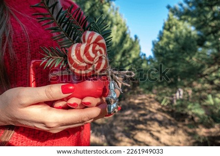 Young woman at  fun picnic in the park holding red cup of latte coffee and lollipop
