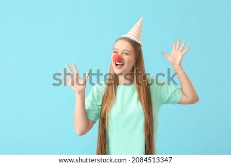Young woman in funny disguise on color background. April Fools Day celebration