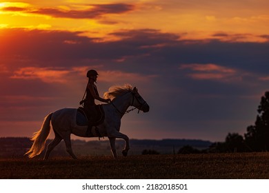 Young Woman Galloping On Horse During Sunset