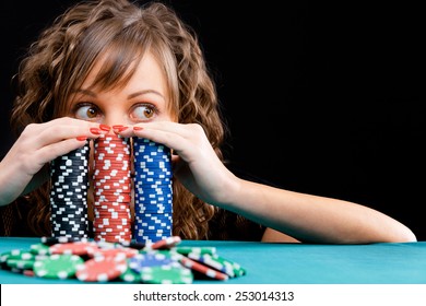 Young woman with gambling chips on black background