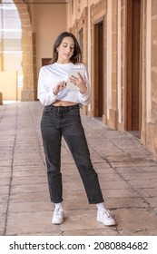 Young Woman Of Generation X Uses Tablet Device In A Sicilian Town