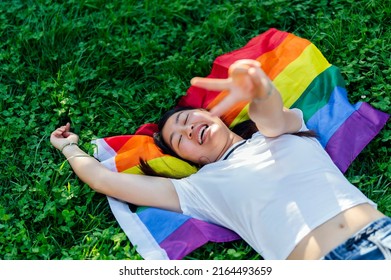 Young Woman Gesturing Peace Sign On Multi Colored Flag