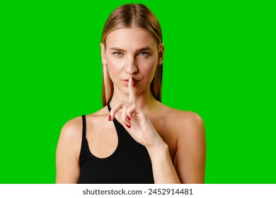 Young Woman Gesturing Silence With Finger on Lips Against Green Screen Background - Powered by Shutterstock