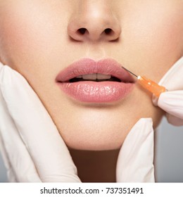 Young Woman Gets Injection Of Botox In Her Lips. Woman In Beauty Salon. Plastic Surgery Clinic.