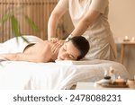 Young woman getting back massage on couch in spa salon