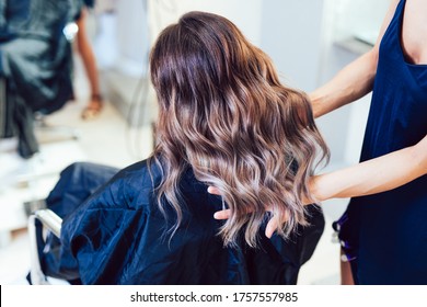 Young woman getting beautiful hairstyle in hair salon.