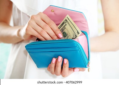 Young Woman Getting Dollars Banknotes From Purse