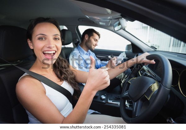 Young woman\
getting a driving lesson in the\
car
