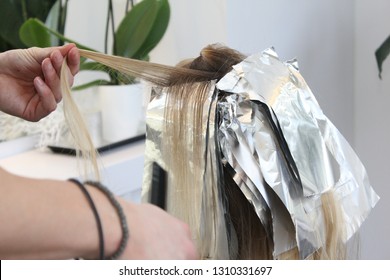Young woman is getting her balayage, blond hairs are dyed