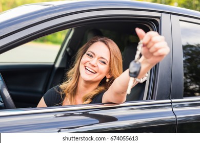 Young woman getting her key in the car. Concept of rent car or buying car