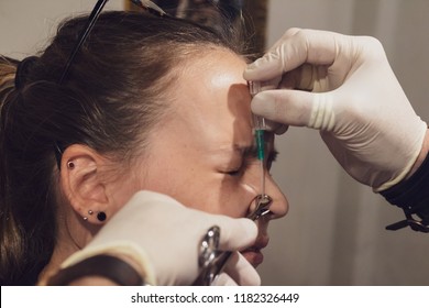 A Young Woman Getting Her Nose Pierced