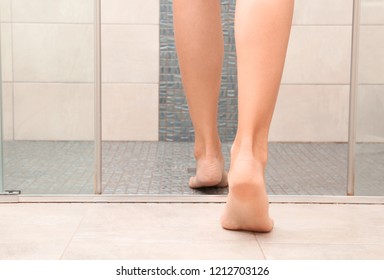 Young Woman Getting Into Shower Cubicle, Focus On Legs