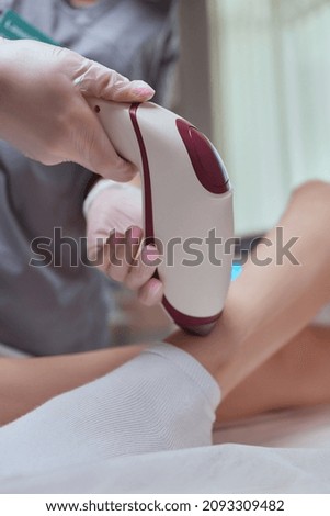 Young woman getting laser hair removal on her thighs.