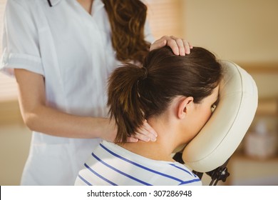 Young Woman Getting Massage In Chair In Therapy Room