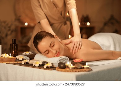 Young woman getting massage in dark spa salon - Powered by Shutterstock