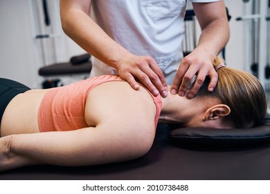 Young woman getting neck, head massage in therapy room. Masseur making chiropractic treatment