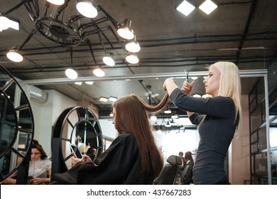 Young Woman Getting New Haircut By Female Hairdresser At Beauty Salon