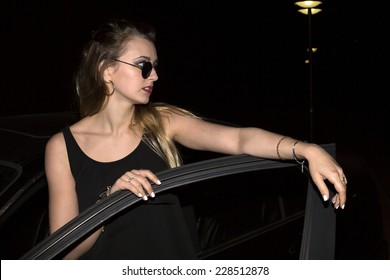 Young Woman Getting Out Of Her Car In The Night