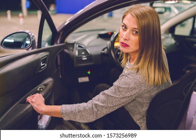 Young Woman Getting Out Of The Parked Car Opening Door Looking To The Camera Mad Angry Furious Pissed On The Parking In The City At Night