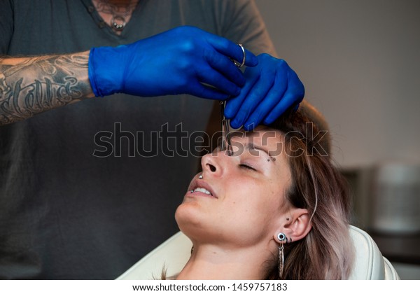 Young Woman Getting Pierced Between Her Stock Image