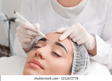 Young Woman Getting Prepared For Procedure Of Permanent Eyebrow Makeup In Tattoo Salon, Closeup