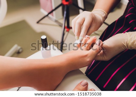 Young woman getting professional pedicure in beauty salon, closeup.