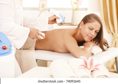 Young Woman Getting Radio Frequency Fat Reduction Treatment In Day Spa.