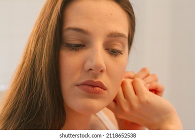 Young Woman Getting Ready For Work Doing Morning Makeup Routine. Putting Earrings