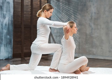 Young woman is getting Thai massage treatment by therapist. Traditional Asian stretching therapy.