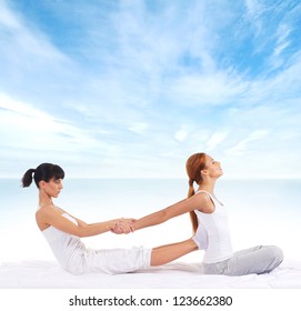 Young woman getting traditional thai stretching massage by therapist isolated on sea and sky background