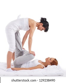 Young woman getting traditional thai stretching massage by therapist isolated on white background