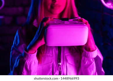 Young Woman Girl Gamer Hold Vr Headset Ar Innovative Glasses Watch 3d 360 Video Play Game In Futuristic Purple Neon Light, Virtual Augmented Reality Cyber Space Technology Concept, Close Up View