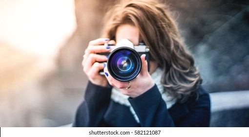Young woman girl photographer with blue camera lens