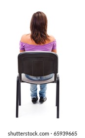 A Young Woman / Girl Sitting On A Chair Looking Forward With Her Back Facing To The Camera.