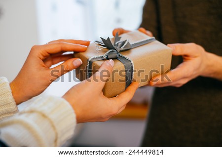 young woman gives a gift in a box